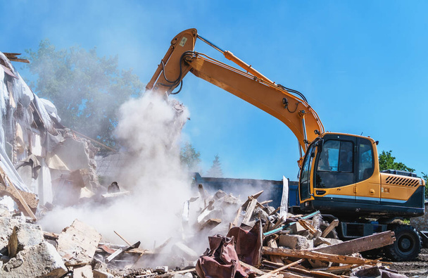 Demolition of building. Excavator destroy old house. - Foto, imagen