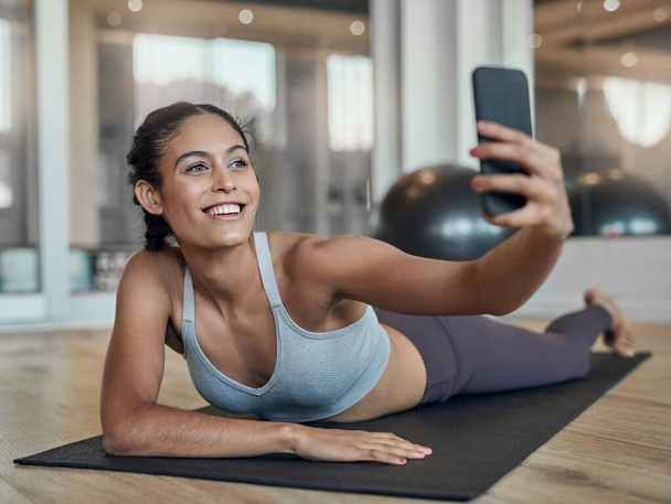 Fitness-Selfies bekommen viele Likes. Aufnahme einer attraktiven jungen Sportlerin, die Selfies im Fitnessstudio macht - Foto, Bild