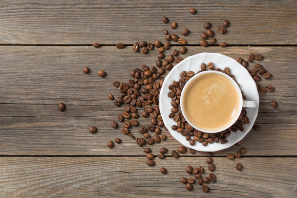 木製のテーブルでコーヒー豆とコーヒーの新鮮なカップを朝 - 写真・画像