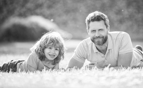 щасливий сімейний портрет батька і сина дитина відпочиває в літньому парку зелена трава, літній відпочинок
. - Фото, зображення