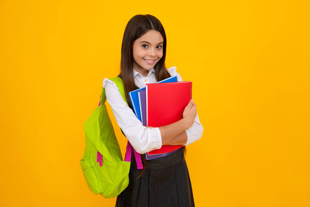 Back to school. Schoolgirl student with school bag backpack hold book on isolated studio background. School and education concept. Teenager girl in school uniform - Fotó, kép