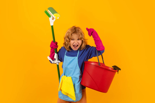 Dzieci pomagające w sprzątaniu domu. Pokojówka w domu. słodkie dziecko chłopiec pomaga w sprzątaniu na żółty studio backdround - Zdjęcie, obraz