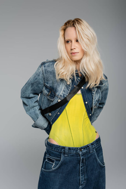 blonde albino woman in blue denim outfit posing isolated on grey  - Foto, imagen