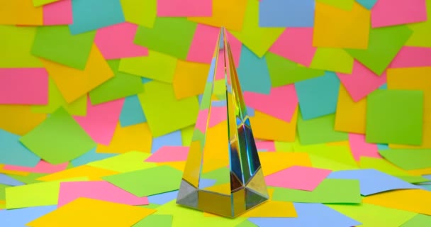 pirámide de cristal girando en notas adhesivas de colores en el fondo - Metraje, vídeo