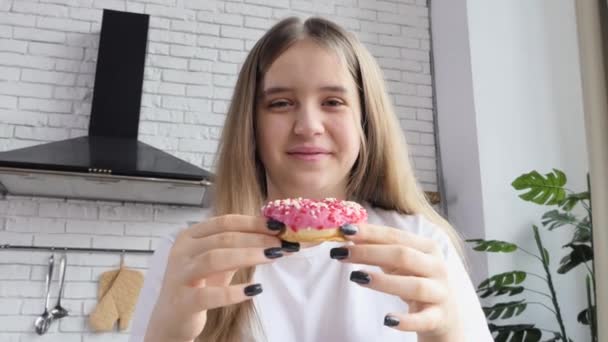 schöne Frau essen Donut genießen süßen köstlichen Geschmack von Zuckerguss und streut lächelnd mit Zufriedenheit - Filmmaterial, Video