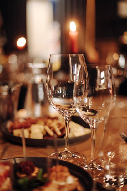 Borkóstoló élmény a rusztikus pincében és borbárban: vörösboros pohár és kiváló borok gyűjteménye a háttérben. Kiváló minőségű fénykép - Fotó, kép