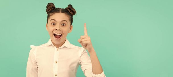 Everything begins with an idea. Happy child keep finger up blue background. Back to school idea. Child face, horizontal poster, teenager girl isolated portrait, banner with copy space - Fotó, kép