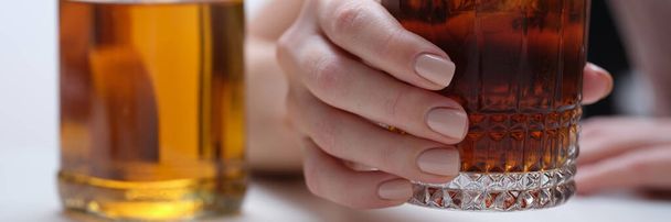 Жіноча рука тримає склянку віскі або коньяку з пляшкою. Жінка, яка страждає від алкогольної залежності та депресії, п'є концепцію жорсткого алкоголю
 - Фото, зображення
