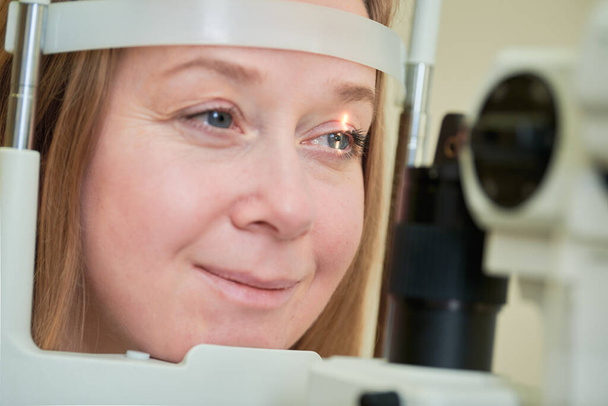 ophthalmology. female patient under eyesight check at optometrist eye doctor. astigmatism diagnosis at clinic. Eyecare consultation service. - Valokuva, kuva