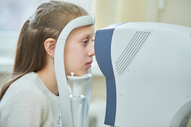 οφθαλμολογικές υπηρεσίες. μικρό κορίτσι στην εξέταση όρασης στην κλινική - Φωτογραφία, εικόνα