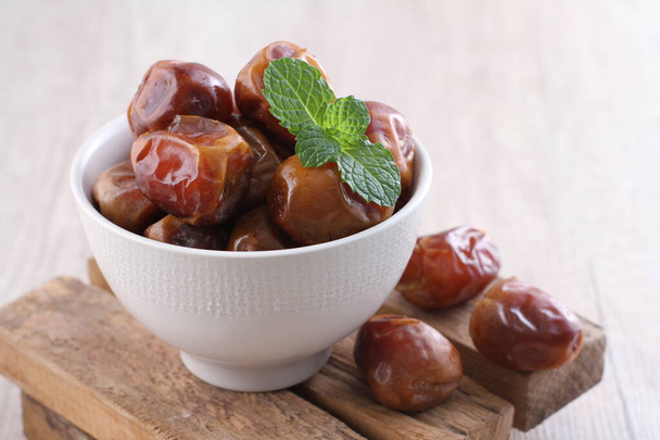 traditional arabic dates in a bowl on a wooden background - Foto, Imagen
