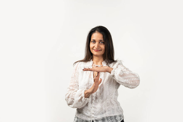 Indian mid age serious woman showing a time out gesture with hands, isolated white background - Fotografie, Obrázek