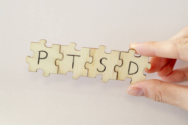 Hand Writing PTSD on wooden puzzles. Post traumatic stress disorder - 写真・画像