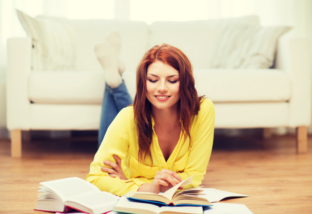 smiling student girl reading books at home - Foto, Imagen