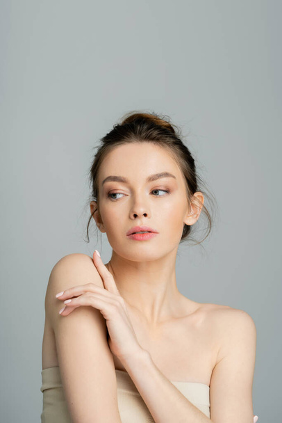 young woman with bare shoulders and natural makeup posing isolated on grey - Fotografie, Obrázek