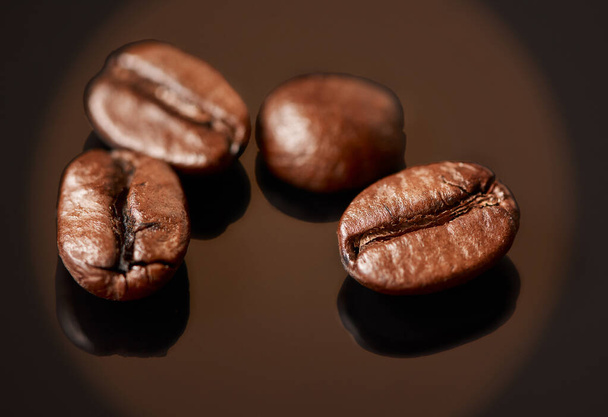 コーヒーが直らないものは何もない。茶色の背景を背景にしたコーヒー豆のスタジオショット - 写真・画像