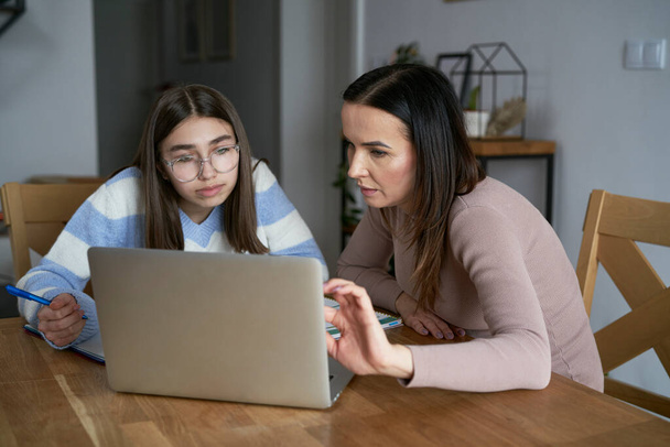 Caucasian mother with teenager daughter make homework at home - Foto, Bild