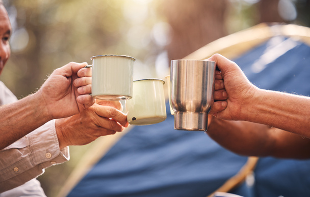 Camping hands, mugs and people toast on outdoor nature vacation for wellness, freedom or natural forest peace. Drinks, group cheers and relax friends celebrate on holiday adventure in Australia woods. - 写真・画像
