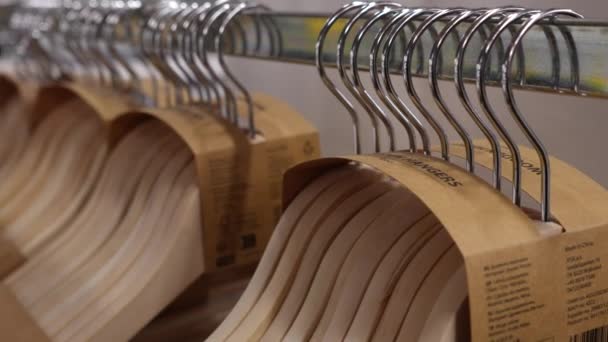 Nieuwe lege houten kleerhangers op de toonbank. Verkoop van trempels voor kleding. Close-up. - Video