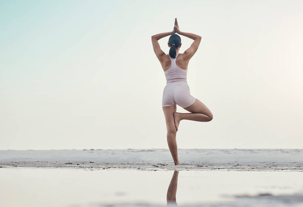 Rückansicht, Balance-Pose und Yoga von Frauen am Strand für Wellness, Zen und Frieden gegen Ozean-Attrappe. Rücken, Stehen und Meditation durch Mädchen am Meer für Energie, Bewegung und Fitnesstraining. - Foto, Bild
