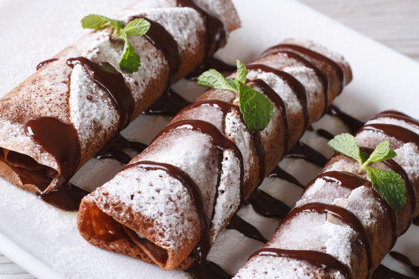 chocolade pannenkoeken met saus en mint close-up horizontaal - Foto, afbeelding