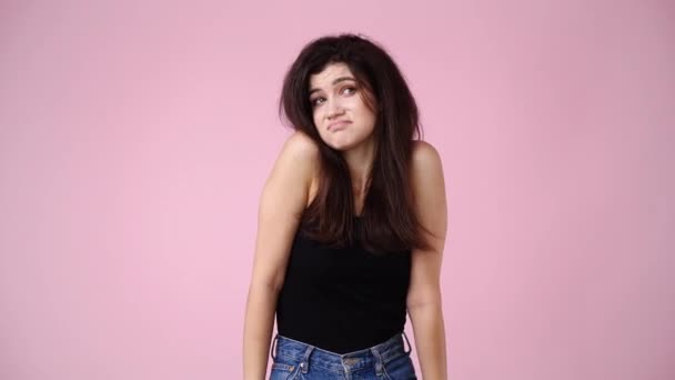 4k video of one cute girl doubts over pink background. Concept of emotions. - Footage, Video