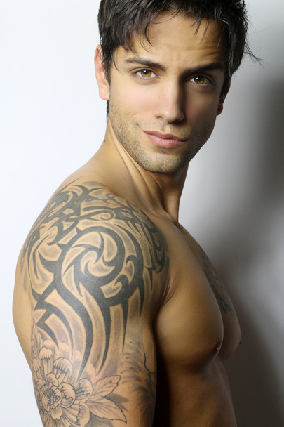 Красивий м'язистий і татуйований чоловік посміхається
 - Фото, зображення