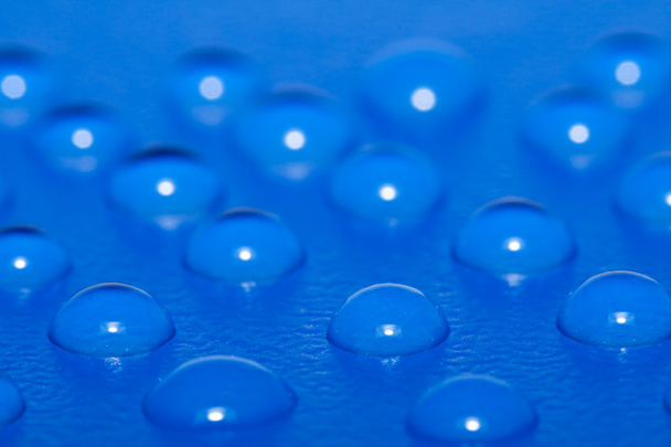 Gotas de agua en superficie azul
 - Foto, imagen