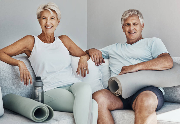 Fitness, yoga et portrait de couple de personnes âgées sur le canapé sourire prêt pour le bien-être, le corps sain et l'entraînement. Sports, retraite et personnes âgées heureuses avec tapis de gym pour l'exercice, l'entraînement et les pilates. - Photo, image