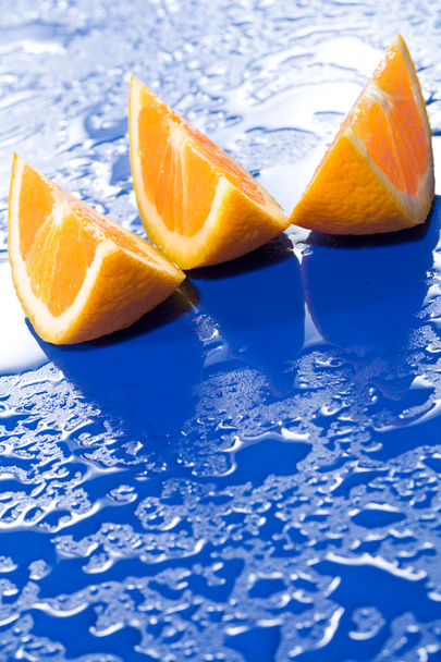 φέτες πορτοκαλιού στην επιφάνεια μπλε - Φωτογραφία, εικόνα