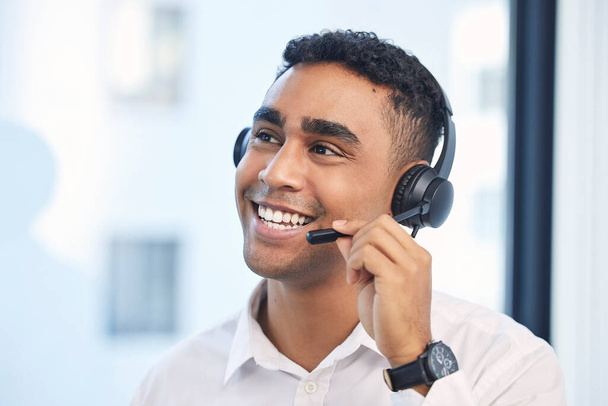 Τηλεφωνικό κέντρο, συμβουλευτική και χαμόγελο με τον άνθρωπο στο γραφείο για την υποστήριξη πελατών, το τηλεμάρκετινγκ ή την επικοινωνία. Πωλήσεις, συμβουλές και χαρούμενος με τον εργαζόμενο για γραφείο βοήθειας, επικοινωνήστε μαζί μας και διαφημιστικός πράκτορας. - Φωτογραφία, εικόνα