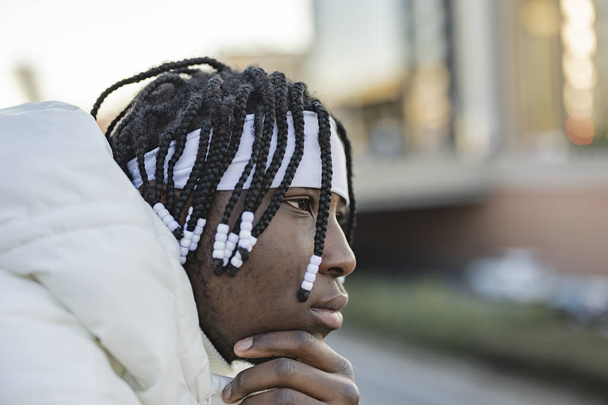 joven africano con rastas en la ciudad - retrato de cerca de un tipo mirando al horizonte - - Foto, Imagen