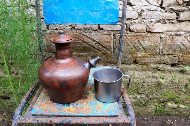 Cserépedény vagy teáskanna. egy hely, ahol agyagból lehet vizet tárolni. hagyományos hajók vidéken. agyagból készült kézművesség. - Fotó, kép