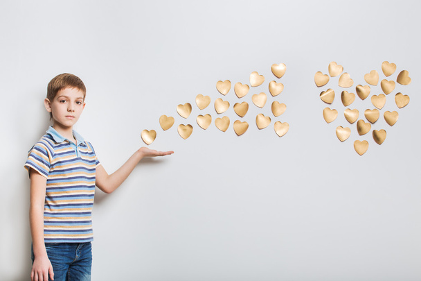 Boy holding flying golden hearts - Foto, Imagen