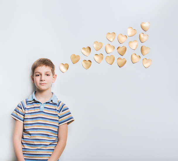 Boy thinking with golden hearts over light grey background - Foto, immagini