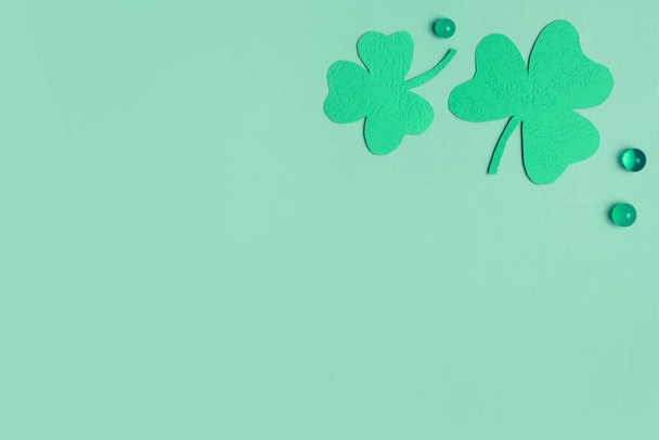 St. Patrick's Day minimalistic concept. Paper clover leaves on colored background with copy space. - Foto, Imagem