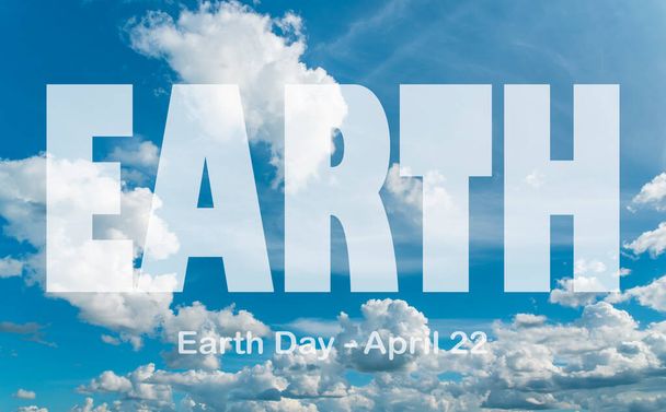 Lettering Earth Day April 22 on the background of cloudy sky. Earth day concept, protection of the planet from pollution, improvement of environmental ecology and nature conservation. - Photo, Image