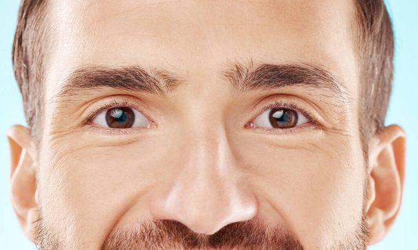 Skincare, vision and zoom on man eyes, beauty and grooming portrait isolated on blue background. Eye care, health and facial wellness, good eyesight and glowing skin on happy male model in studio - Photo, image