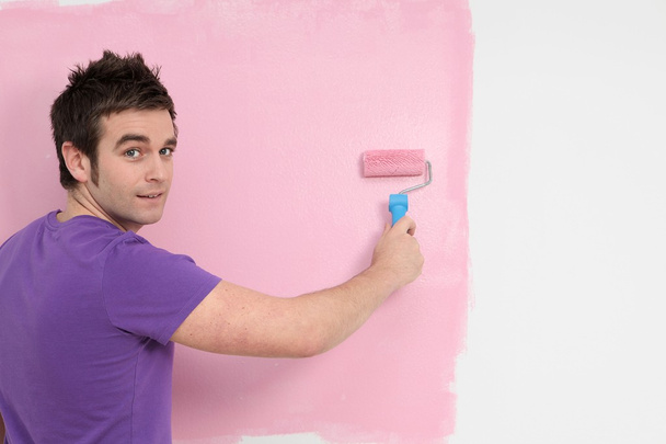 Young man painting decorating with roller brush - Photo, Image