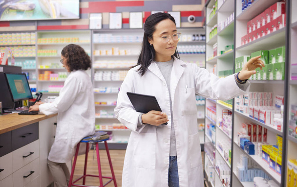 Pharmacy, tablet and pharmacist woman for medicine management, stock research and inventory data app. Digital technology, retail logistics and asian healthcare doctor or person for product data check. - Photo, image