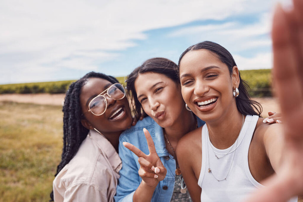 Peace sign, friends and selfie with women in nature for social media, bonding and summer break. Smile, diversity and happiness with portrait of girl in outdoor park for adventure, freedom and youth. - Photo, Image