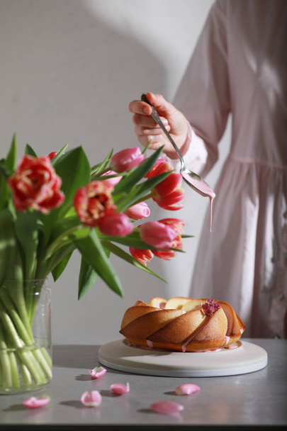  Vrouw versieren bundt cake met beglazing, close-up uitzicht van de hand versieren van de taart.  - Foto, afbeelding