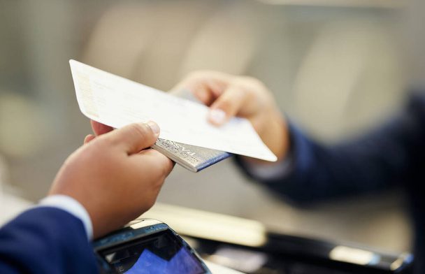 Εισιτήριο, αεροδρόμιο και άτομο με διαβατήριο στον πάγκο για ταξιδιωτικά έγγραφα, ταυτότητα ασφαλείας και αεροπορικό ταξίδι. Χέρια, έγγραφα μεταφοράς επιβατών και ταυτότητας για check in, κράτηση και μεταφορά πτήσης. - Φωτογραφία, εικόνα