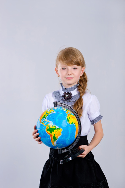 Cute beautiful schoolgirl with a globe - Fotó, kép