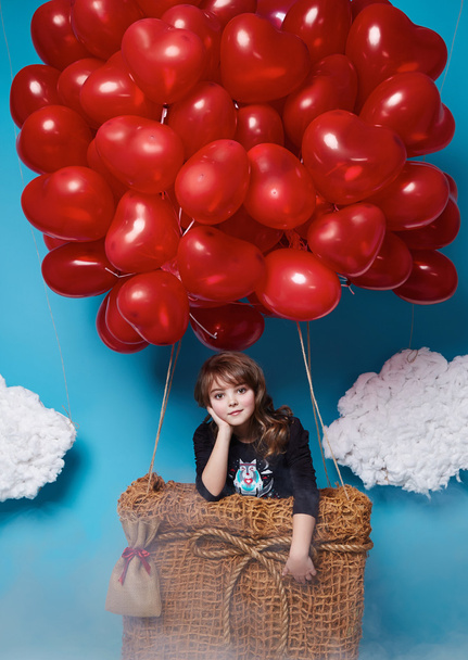 Small cute girl flying on red heart balloons Valentines day - Photo, Image