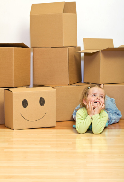 Little girl laying on the floor with lots of cardboard boxes - Foto, Imagem