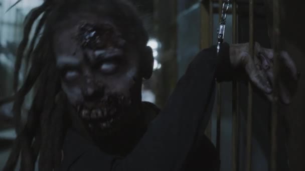 Váll-up női gonosz zombi elfogott és biztosított bilincs rángatózás hátborzongató alagsorban fények villogó ipari épület - Felvétel, videó