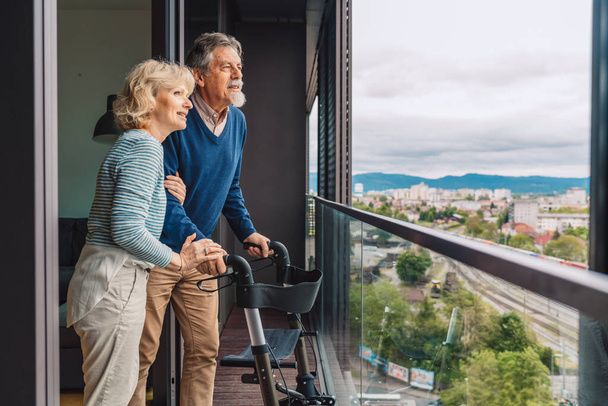 Ouder echtpaar op het balkon met uitzicht op de stad. Hoge kwaliteit foto - Foto, afbeelding