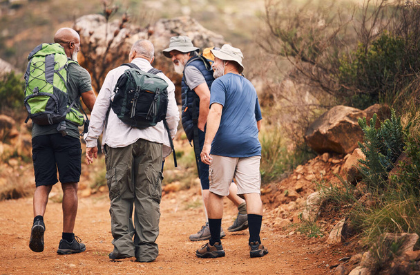 Hiking, travel and walk with old men on mountain for fitness, trekking and backpacking adventure. Explorer, discovery and group with elderly friends in nature for health, retirement and journey. - Foto, Imagem