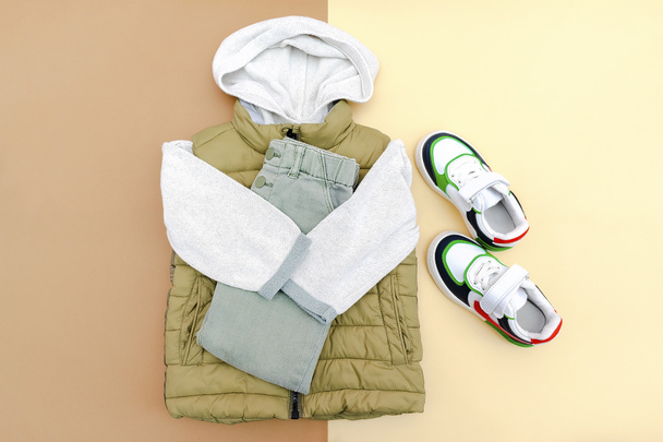 Vest,jumper,hooded sweatshirt,knitted,jeans pants with sneakers.Set of baby children's clothes,clothing,accessories for spring,autumn,winter on brown background.Fashion kids outfit.top view. - Foto, Imagem
